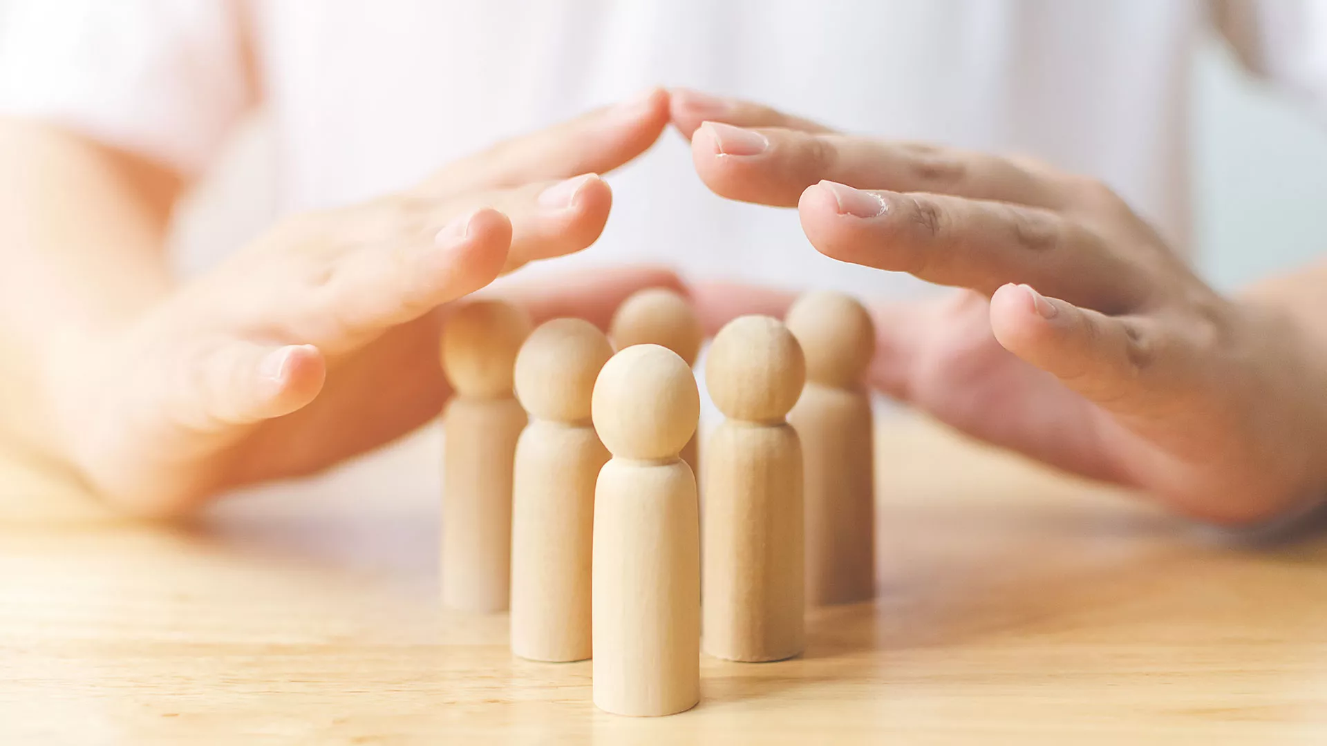 hands held over wooden figurines